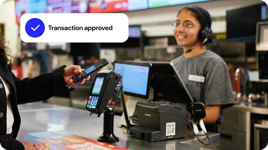 A server picks up a meal from the kitchen to deliver it to a customer.